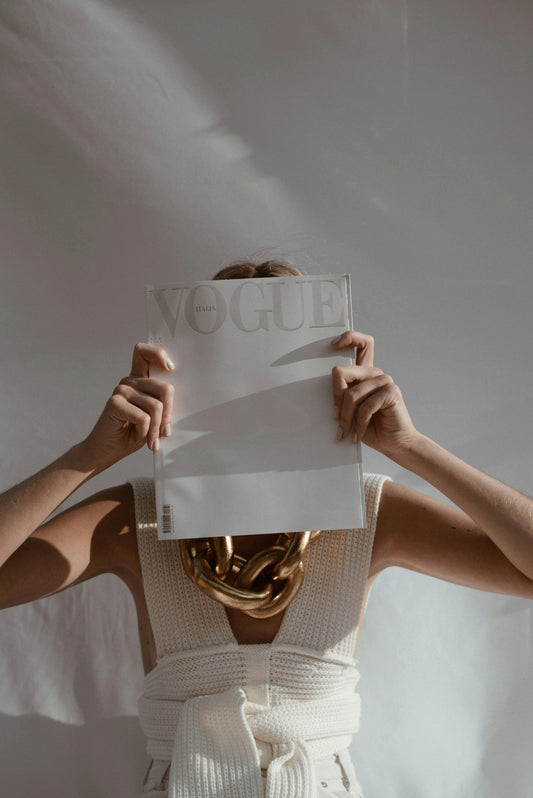 10 Essential Fashion Styling Tips for Women - A women holding a paper in front of her face with a white background